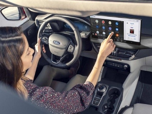 2024 Ford Escape Plug-in Hybrid view of woman in driver seat using touchscreen display