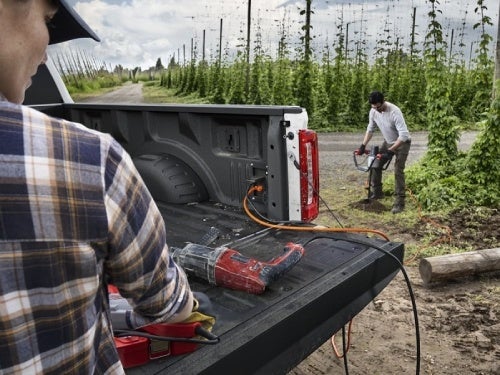 2024 Ford Super Duty view of man using pro power onboard for power tools