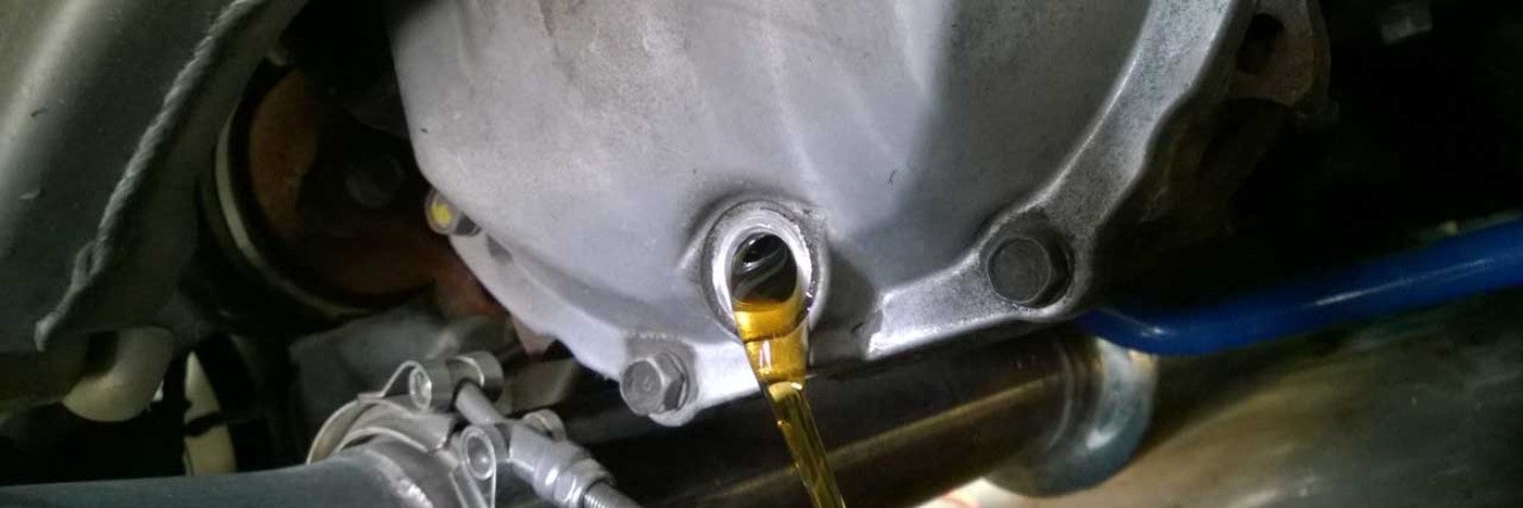 Close up view of yellow colored liquid being poured from a metal tank
